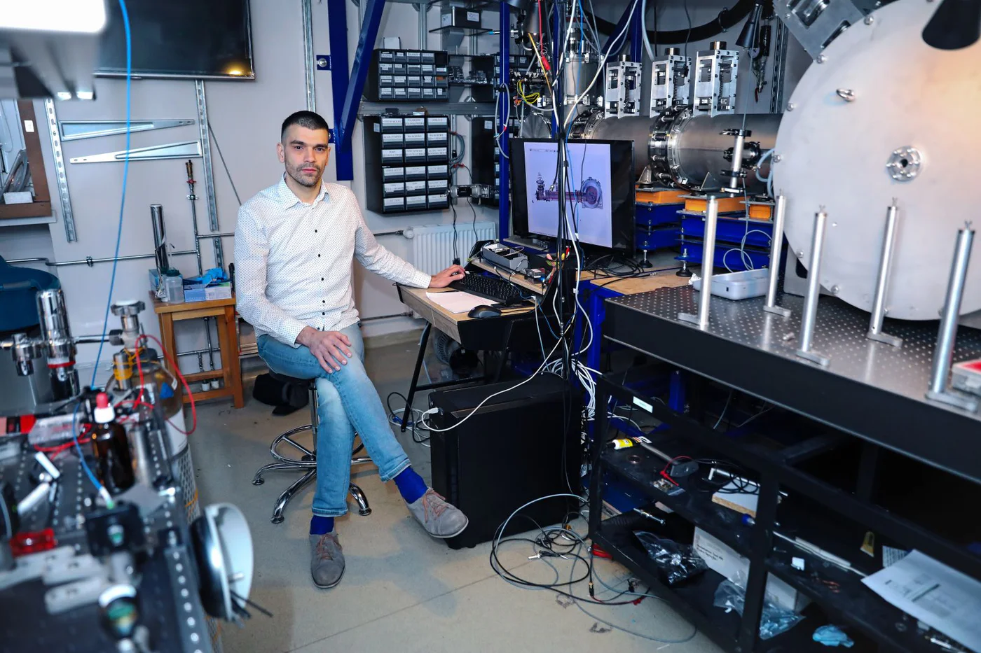 Piotr Wcisło in the laboratory alongside precision spectroscopy equipment