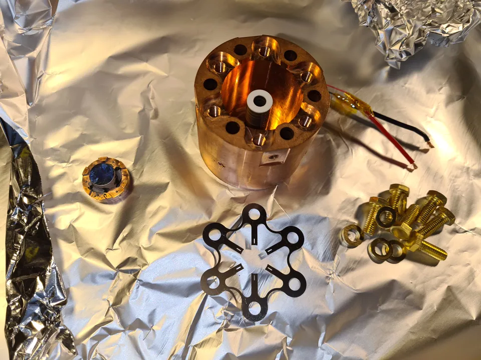 Disassembled mirror actuator with copper housing and spring plates